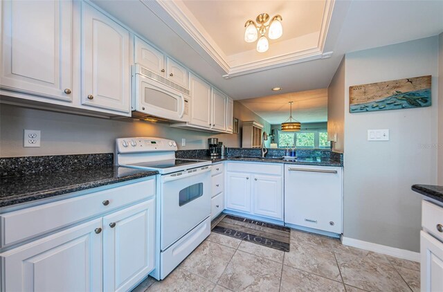 kitchen featuring white cabinets, a sink, dark stone countertops, white appliances, and pendant lighting
