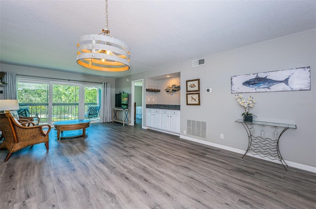 living area featuring wood finished floors, visible vents, and baseboards