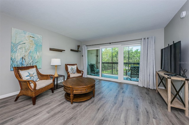 living area with wood finished floors and baseboards