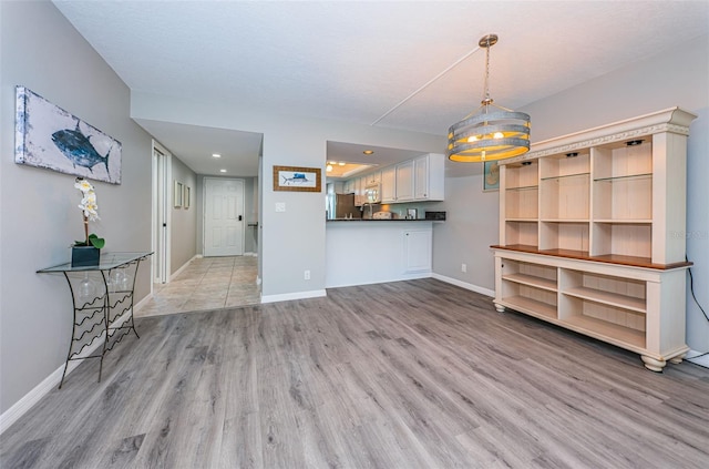 unfurnished living room featuring light wood finished floors, baseboards, and recessed lighting