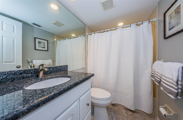 bathroom featuring toilet, vanity, and visible vents