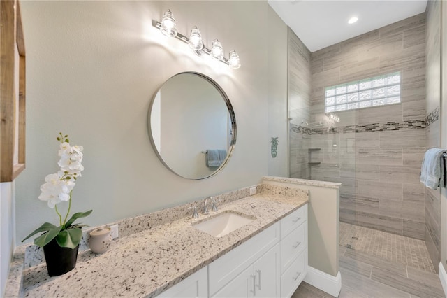 bathroom with recessed lighting, walk in shower, and vanity