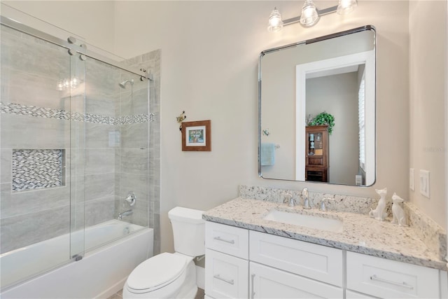 full bathroom featuring vanity, shower / bath combination with glass door, and toilet