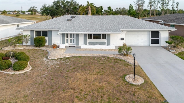 single story home with a garage, stucco siding, concrete driveway, and roof with shingles