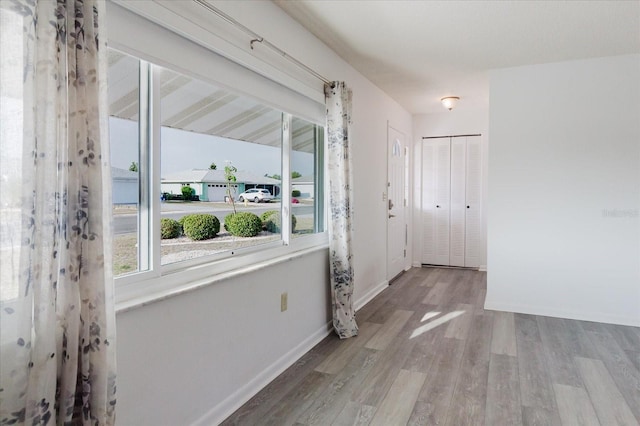 corridor with baseboards and wood finished floors