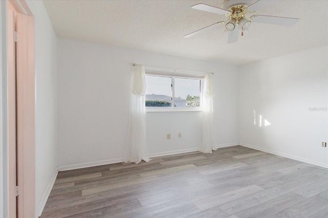 unfurnished room with baseboards, ceiling fan, and wood finished floors
