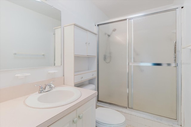 full bathroom featuring vanity, an enclosed shower, and toilet