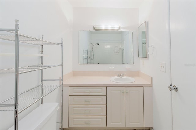 bathroom with vanity, toilet, and a shower