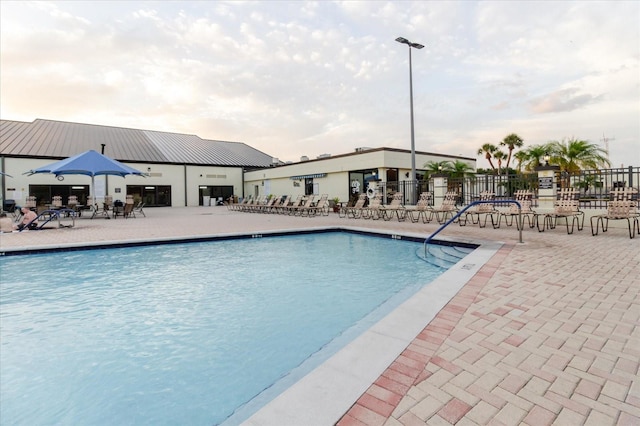 community pool featuring fence and a patio
