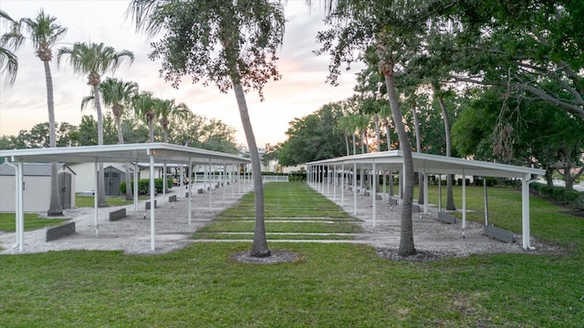 view of community with an outdoor structure, a yard, and a shed