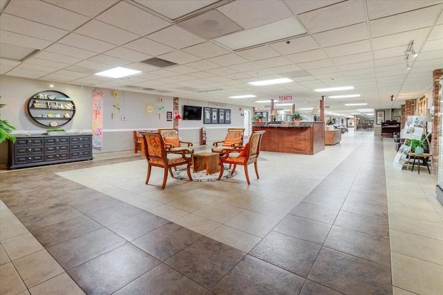 dining area featuring a paneled ceiling and tile patterned flooring