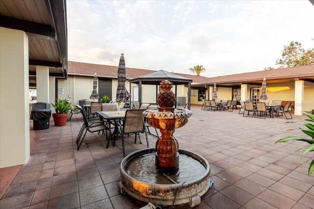 view of patio with outdoor dining area and a gazebo