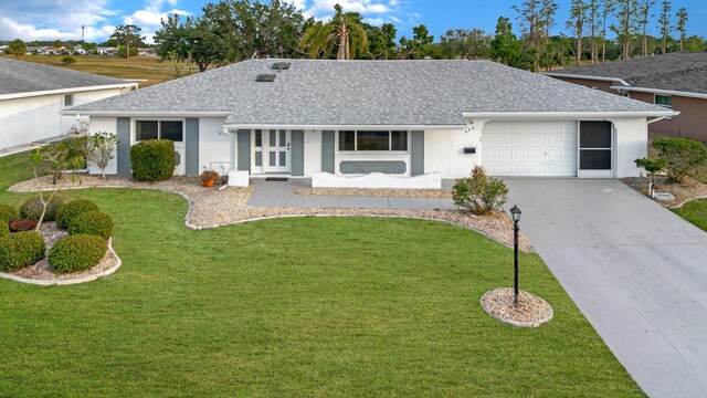 646 Allegheny Dr, Sun City Center, FL 33573 - ranch-style house featuring an attached garage, roof with shingles, driveway, and a front lawn