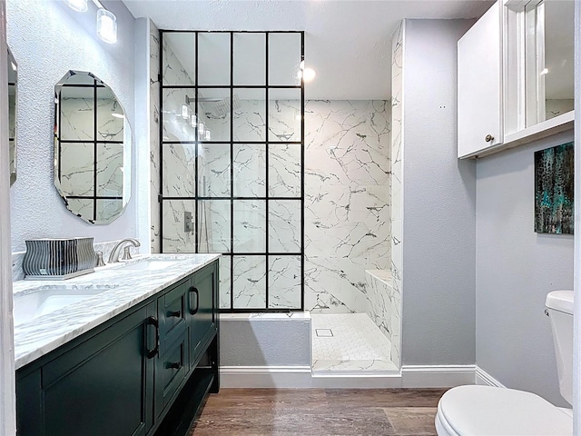 6811 S Himes Ave, Tampa, FL 33611 - bathroom with toilet, a tile shower, wood finished floors, and double vanity