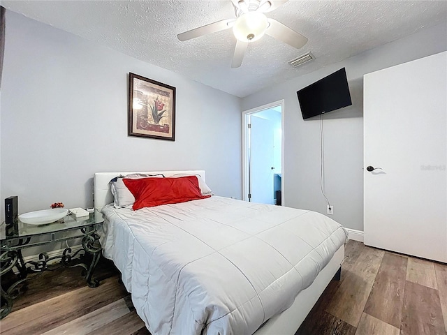 6811 S Himes Ave, Tampa, FL 33611 - bedroom with wood finished floors, a textured ceiling, a ceiling fan, and baseboards