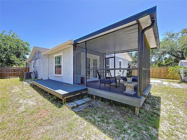 6811 S Himes Ave, Tampa, FL 33611 - back of property with a fenced backyard, a wooden deck, central AC unit, french doors, and stucco siding