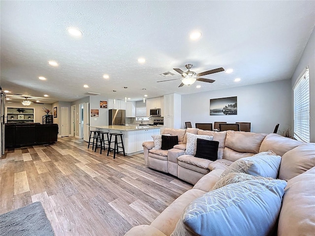 6811 S Himes Ave, Tampa, FL 33611 - living room with ceiling fan, recessed lighting, light wood-style floors, and a textured ceiling