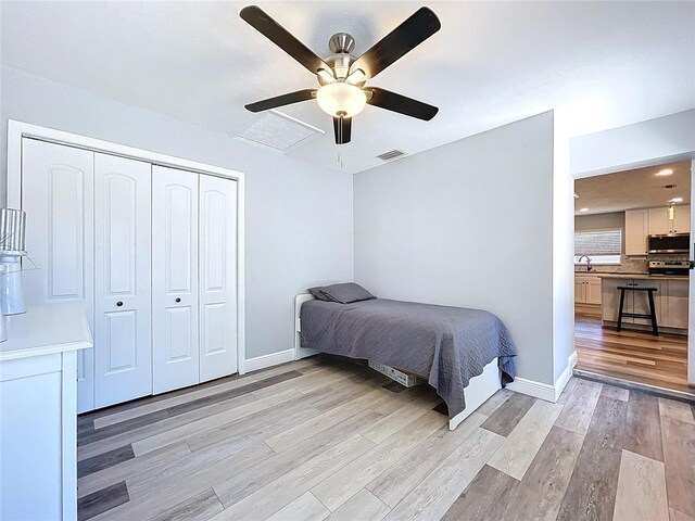 6811 S Himes Ave, Tampa, FL 33611 - bedroom featuring light wood-style floors, a closet, baseboards, and a ceiling fan