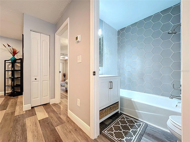 6811 S Himes Ave, Tampa, FL 33611 - full bath with wood finished floors, toilet,  shower combination, baseboards, and vanity