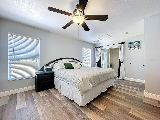 6811 S Himes Ave, Tampa, FL 33611 - bedroom with baseboards, wood finished floors, attic access, a ceiling fan, and a textured ceiling