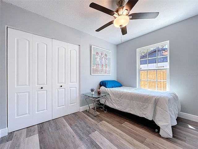 6811 S Himes Ave, Tampa, FL 33611 - bedroom with baseboards, a closet, wood finished floors, a ceiling fan, and a textured ceiling