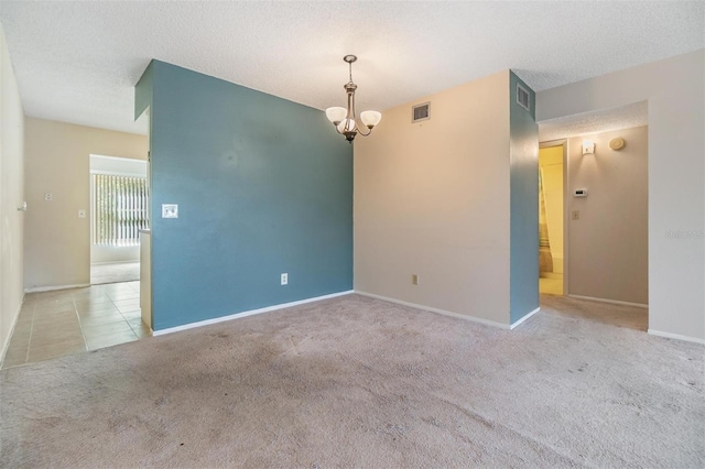 2310 Denmark St Unit 30, Clearwater, FL 33763 - carpeted empty room featuring a chandelier, a textured ceiling, baseboards, and tile patterned flooring
