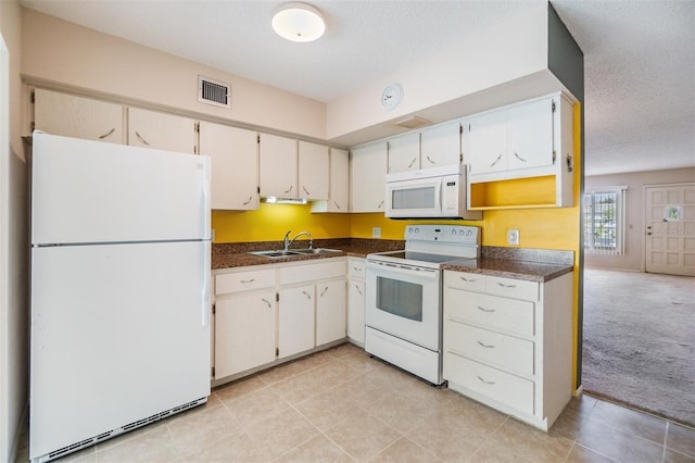 2310 Denmark St Unit 30, Clearwater, FL 33763 - kitchen featuring white appliances, dark countertops, a sink, a textured ceiling, and light tile patterned flooring