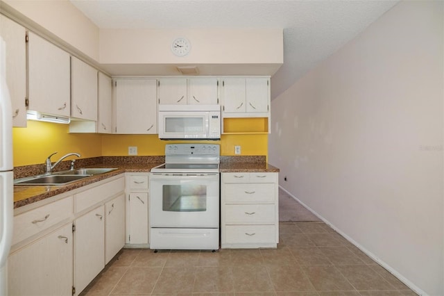 2310 Denmark St Unit 30, Clearwater, FL 33763 - kitchen with white appliances, a sink, dark countertops, and light tile patterned flooring