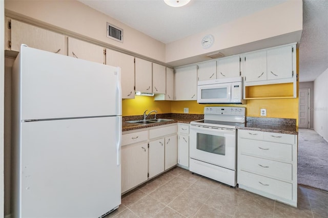 2310 Denmark St Unit 30, Clearwater, FL 33763 - kitchen with white appliances, a sink, dark countertops, light tile patterned floors, and a textured ceiling