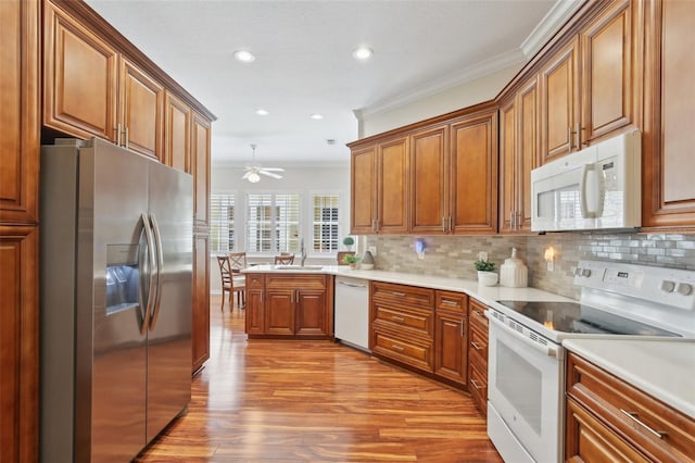 15324 Sherwood Forest Dr, Tampa, FL 33647 - kitchen with white appliances, light wood-type flooring, a sink, decorative backsplash, and crown molding