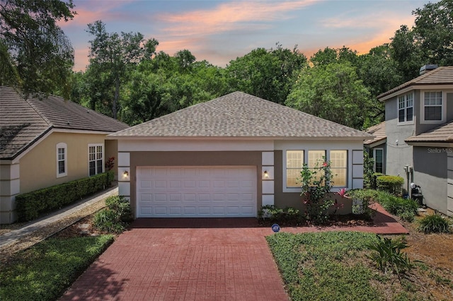 15324 Sherwood Forest Dr, Tampa, FL 33647 - single story home with stucco siding, decorative driveway, an attached garage, and roof with shingles