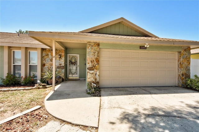 12532 115th St, Largo, FL 33778 - ranch-style home with concrete driveway, an attached garage, and stone siding