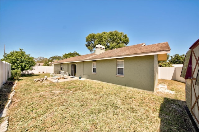 12532 115th St, Largo, FL 33778 - back of house with a patio, a yard, a fenced backyard, a chimney, and stucco siding
