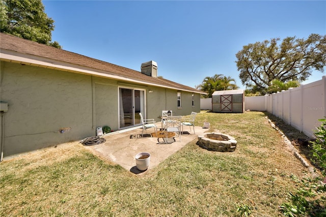 12532 115th St, Largo, FL 33778 - view of yard with an outdoor structure, a fenced backyard, a fire pit, a storage shed, and a patio area