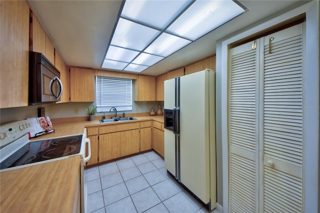 12532 115th St, Largo, FL 33778 - kitchen with light tile patterned floors, white appliances, light countertops, and a sink