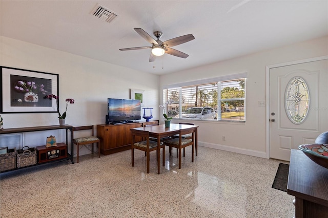 dining room with light speckled floor, visible vents, baseboards, and ceiling fan