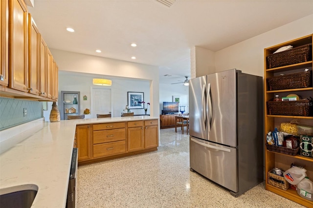 kitchen with a peninsula, light speckled floor, freestanding refrigerator, recessed lighting, and ceiling fan