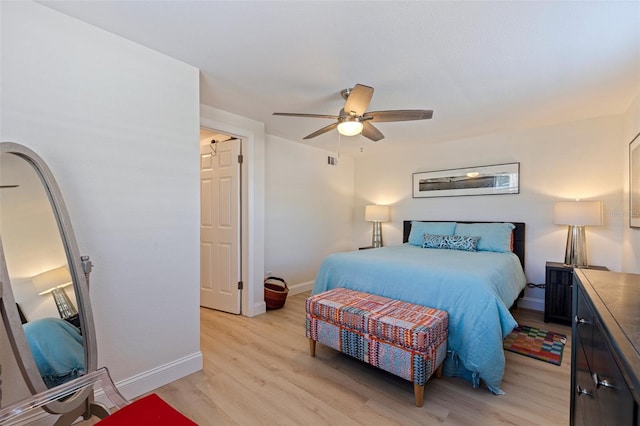 bedroom with light wood finished floors, baseboards, and a ceiling fan