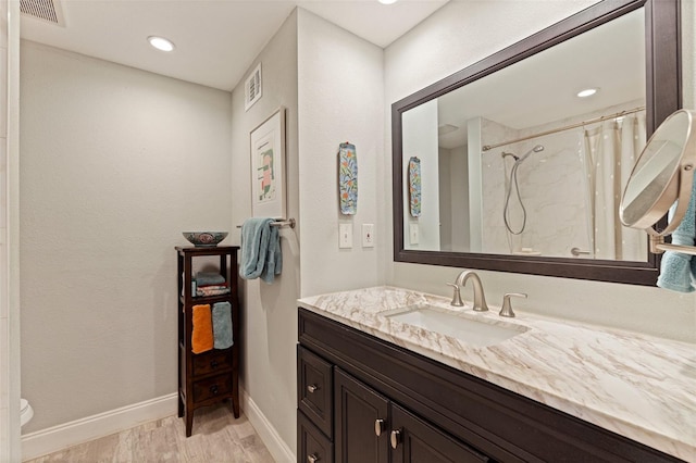 bathroom with a shower with curtain, toilet, baseboards, visible vents, and vanity