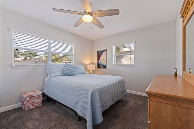 bedroom with dark colored carpet, a ceiling fan, and baseboards