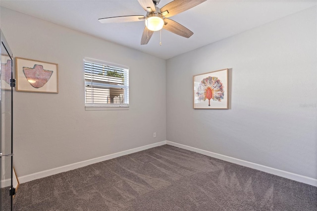 carpeted spare room with a ceiling fan and baseboards