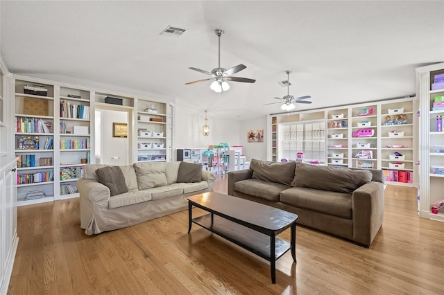 living area with lofted ceiling, visible vents, light wood-type flooring, and ceiling fan