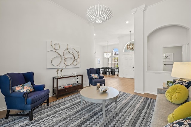 sitting room with baseboards, wood finished floors, and a chandelier