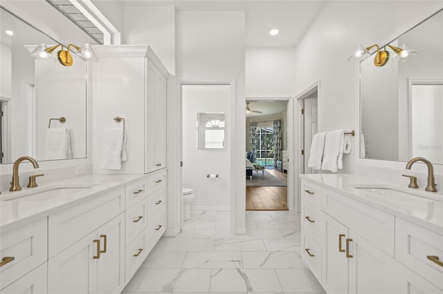 full bathroom featuring recessed lighting, marble finish floor, toilet, and a sink