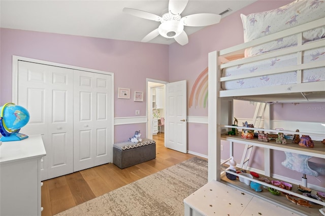 bedroom featuring lofted ceiling, visible vents, a ceiling fan, light wood-style floors, and a closet