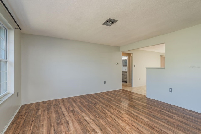 10137 Oleander Dr, Port Richey, FL 34668 - spare room with wood finished floors, healthy amount of natural light, baseboards, and a textured ceiling