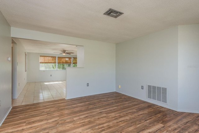 10137 Oleander Dr, Port Richey, FL 34668 - unfurnished room featuring wood finished floors, a textured ceiling, a ceiling fan, and baseboards