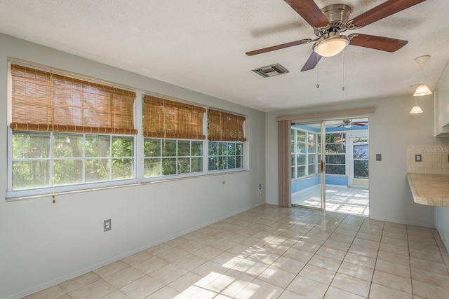 10137 Oleander Dr, Port Richey, FL 34668 - empty room featuring ceiling fan, light tile patterned flooring, a textured ceiling, baseboards, and a sunroom