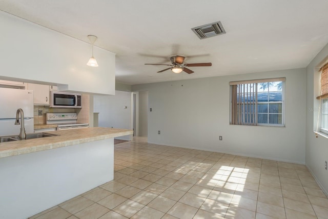 10137 Oleander Dr, Port Richey, FL 34668 - kitchen with white appliances, a sink, light tile patterned floors, and tasteful backsplash