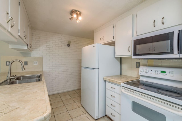 10137 Oleander Dr, Port Richey, FL 34668 - kitchen with white appliances, a sink, brick wall, tasteful backsplash, and white cabinets